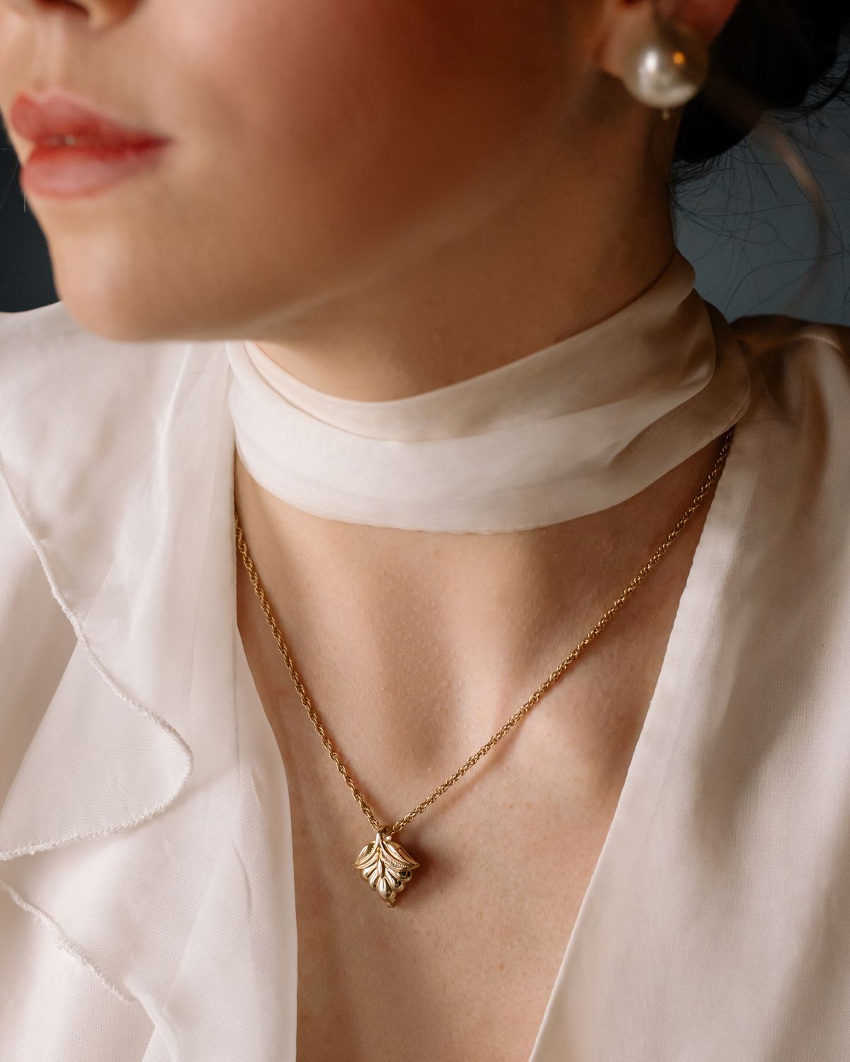 Gold pendant necklace on silk